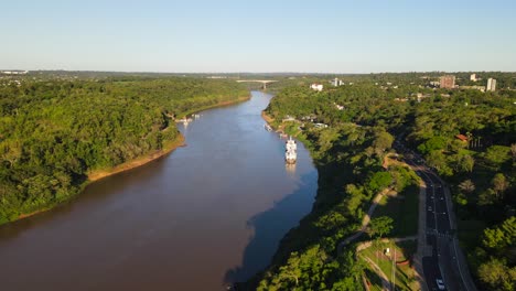 Luftdrohnenaufnahme-Von-Puerto-Iguazu,-Argentinien,-Mit-Der-Brücke-Zwischen-Brasilien-Und-Argentinien-Im-Hintergrund