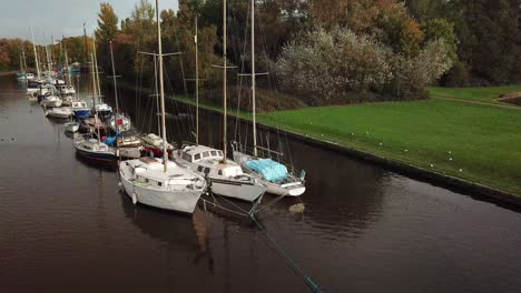 geese landing on water as slow panning rotation around sail boats on canal