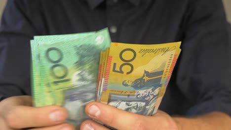 close up of male hands counting australian money