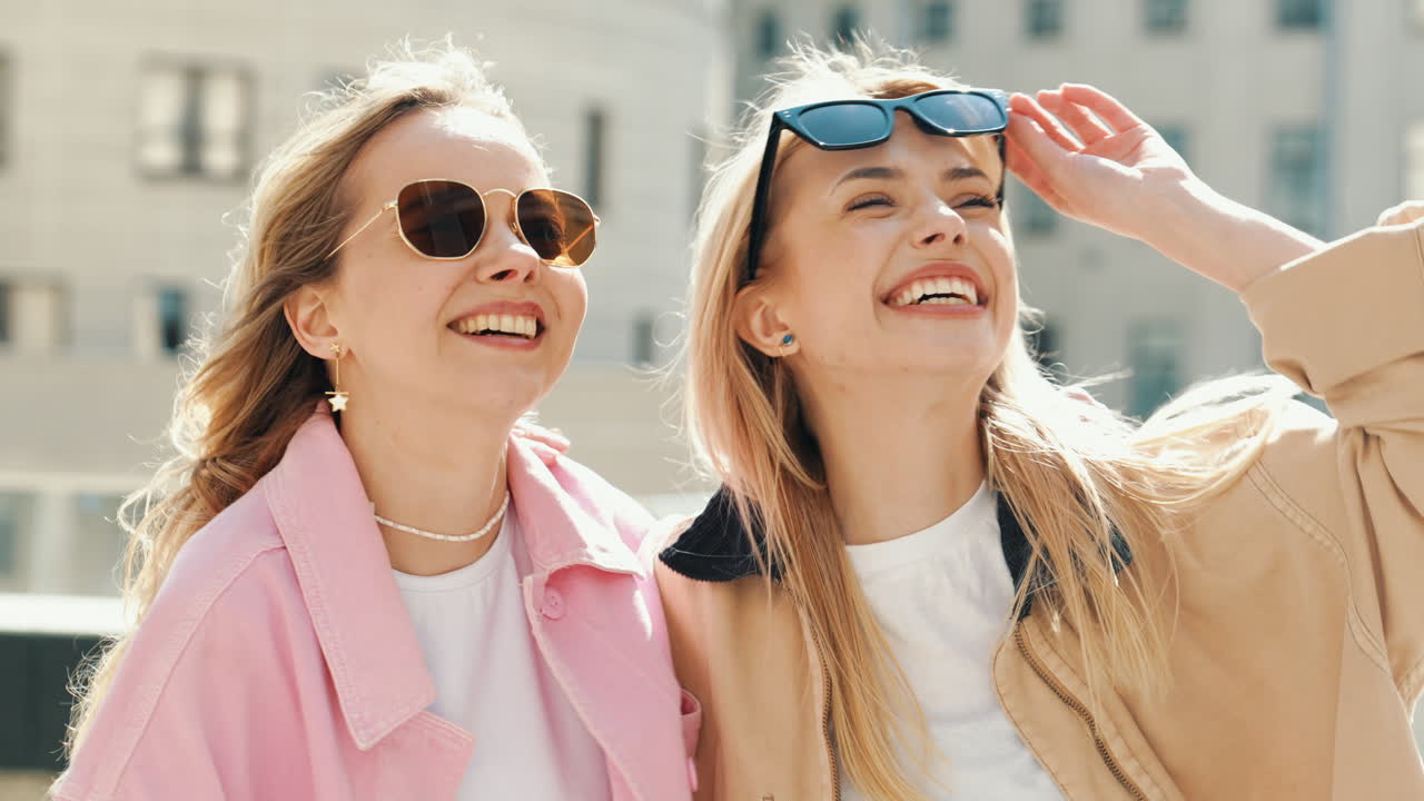 두 명의 행복한 친구들이 도시에서 웃고 빛을 즐기고 있습니다.