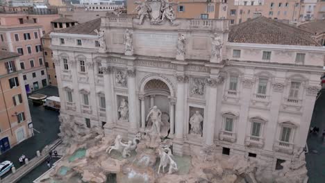 trevi fountain in rome italy - dramatic tilt down aerial reveal