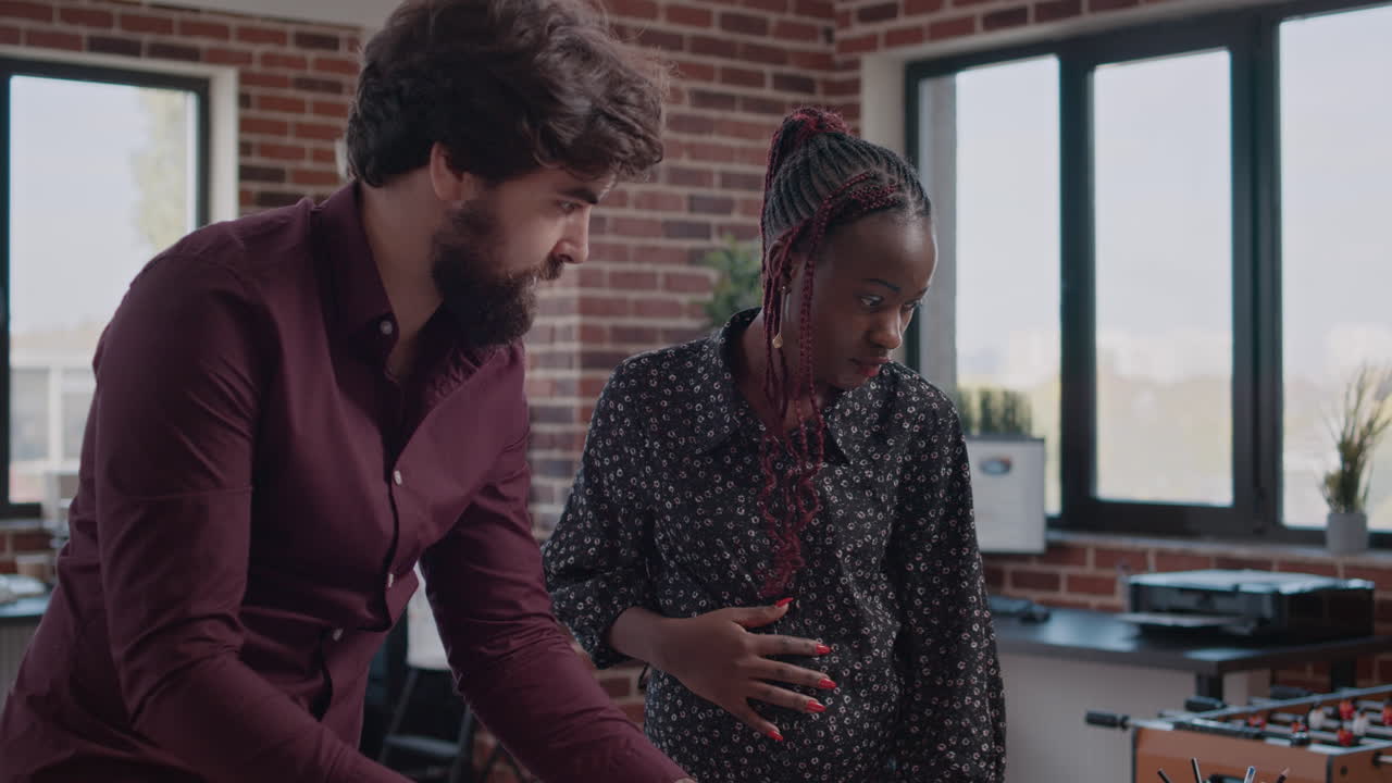 African american pregnant woman working on project planning with man