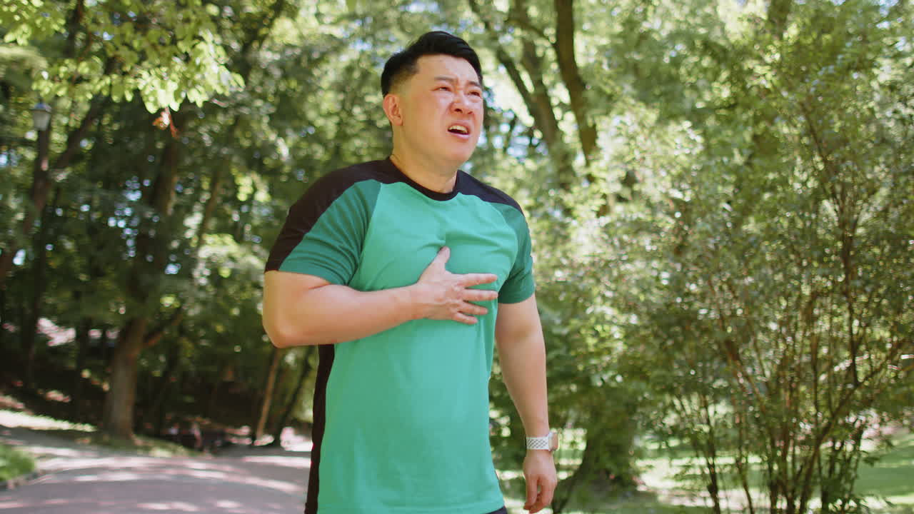 공원에서 운동을 한 후 심장마비나 가 통증이 있는 피곤한 젊은 성인 아시아 선수