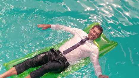 Wet-smiling-businessman-splashing-on-inflatable