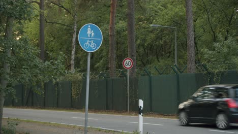 german street signs and a car passing by