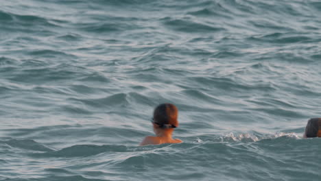 Mother-with-son-bathing-in-wavy-sea