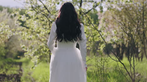 Hermosa-Novia-En-Un-Jardín-Floreciente-En-Primavera-Vista-Trasera-De-La-Figura-Femenina-Vestida-De-Blanco