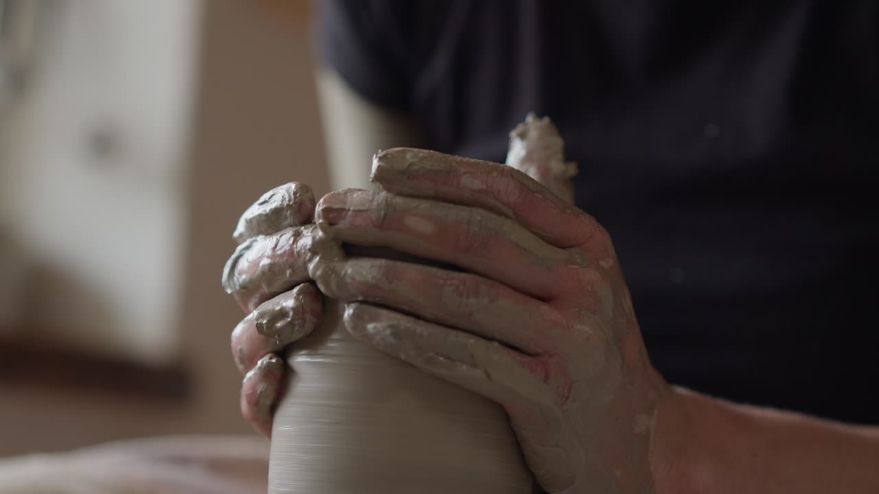 Hands of a Skilled Potter Working with Clay, Forming Artistic Pottery on a Rotating Wheel