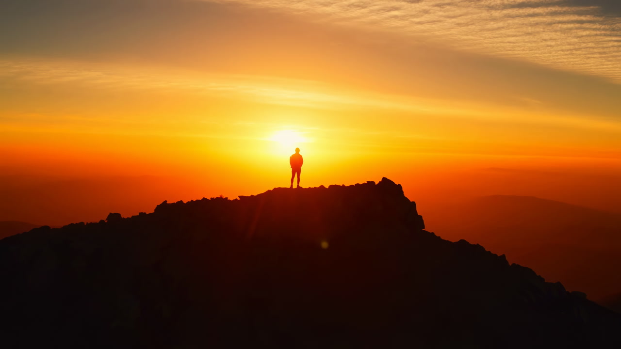Hiker Silhouette On Mountain At Sunrise Golden Sky Expansive Vista Dramatic Clouds Lone Figure On Summit