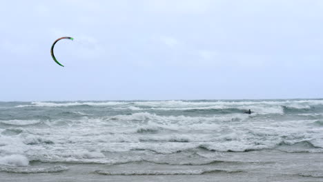 Kiteboarder-En-Cámara-Lenta-Navega-A-Través-De-Las-Olas-En-El-Agua-Del-Océano-Ventoso