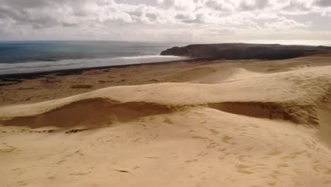 pacific ocean meet giant sand dunes at new zealand coast