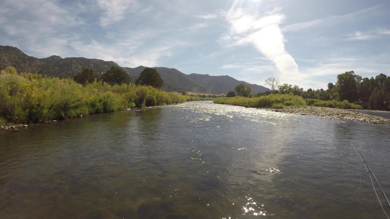 POV shot fly fishing on a river in the mountains.