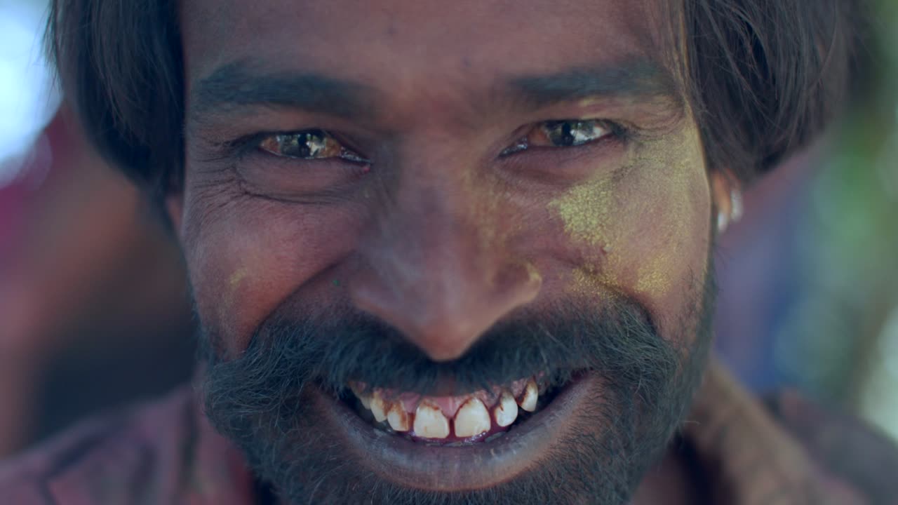 hombre indio de primer plano de la cara manchada con colores brillantes de holi