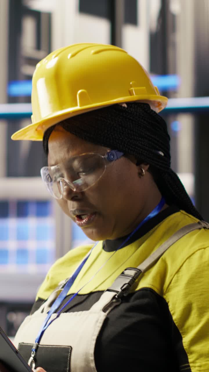 Vertical video Smart solar panels factory engineer using tablet to oversee production lines