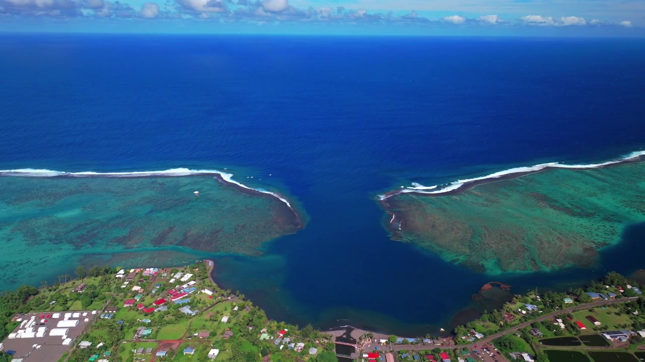 Vista aérea da vila de Teahupo'o, no Fim da Estrada, Taiti, Polinésia Francesa, capturada por drone em uma manhã ensolarada e vibrante, sob um céu azul. O bairro é conhecido pela onda de Teahupo'o, lagoa para surf, Passe Havea, recife de coral e o círculo do Rio Vaiau.