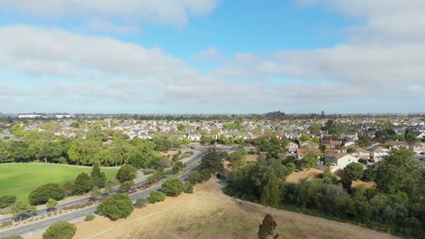 aerial perspective of grassy fields and paved paths winding through open park in salinas area, orbit