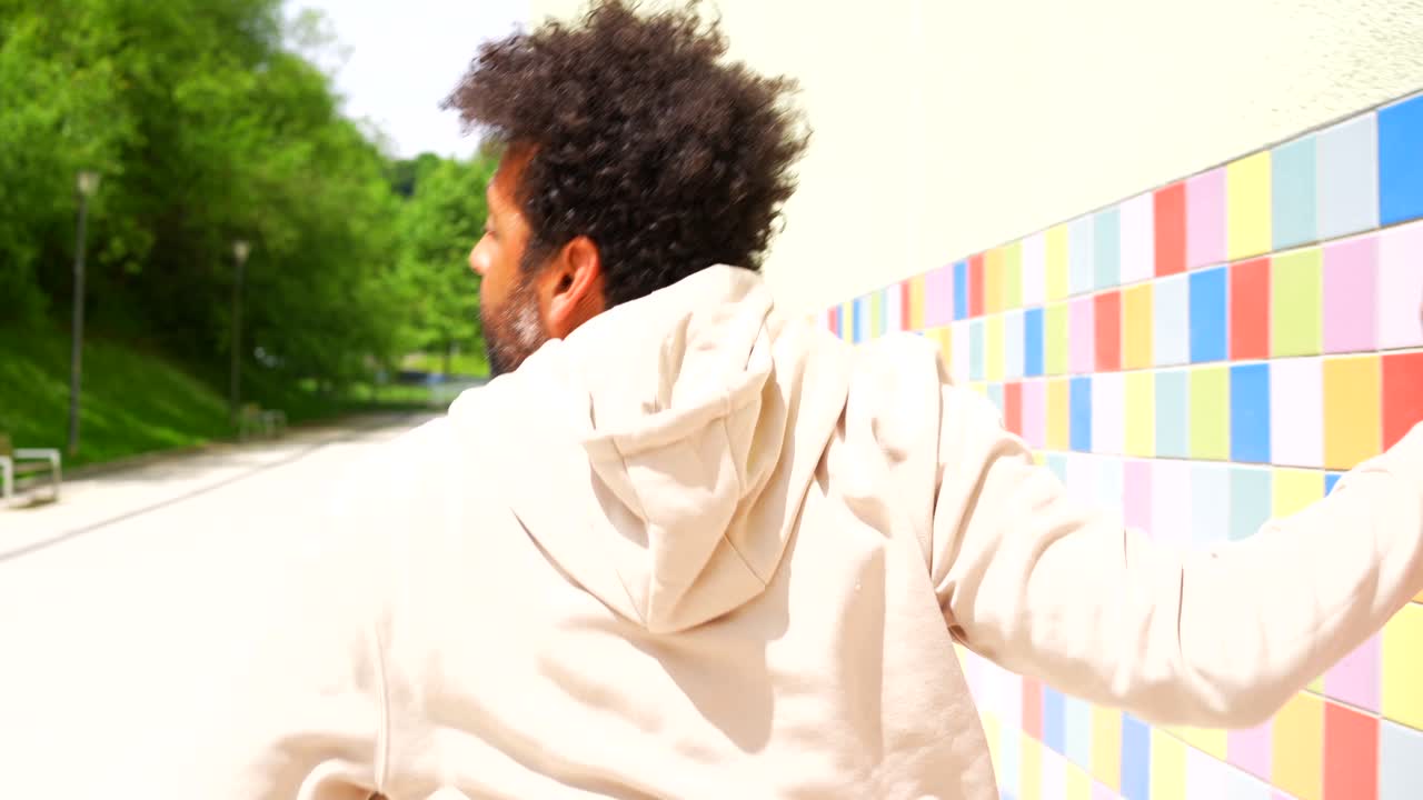 Man posing against colorful tiled wall