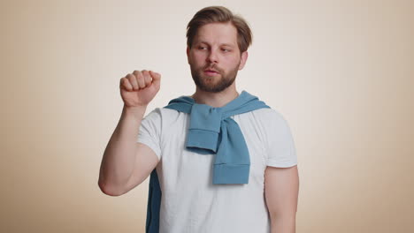 man in a white t-shirt and blue sweater looking serious