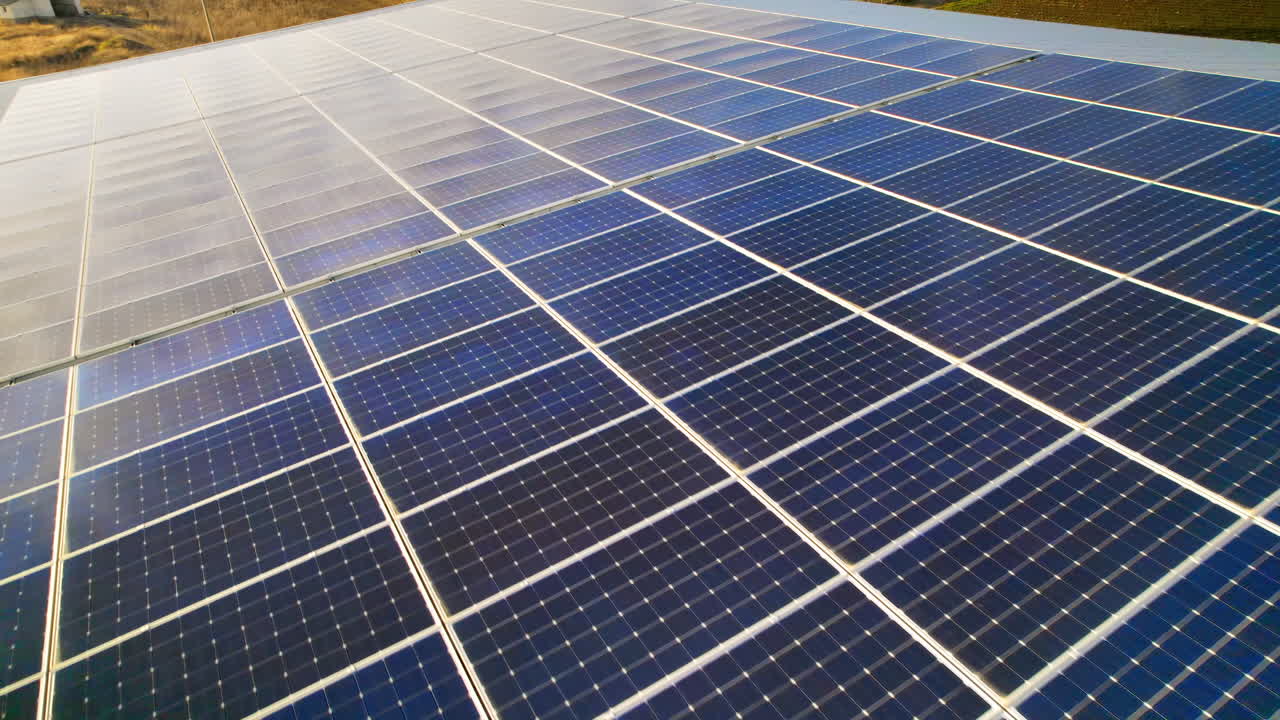 Visão aérea de drone de vários painéis solares no telhado de um prédio de fábrica. Temática de ecologia