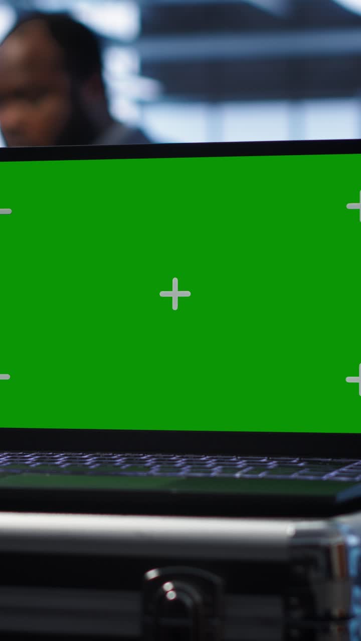 Laptop with Green Screen Display in Office Setting