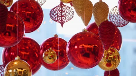 christmas and new year decoration. christmas big red balls on  background of luminous lanterns and gold garlands. holiday background. blinking garland. red baubles with lights twinkling close up.