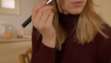 girl doing makeup on herself at home