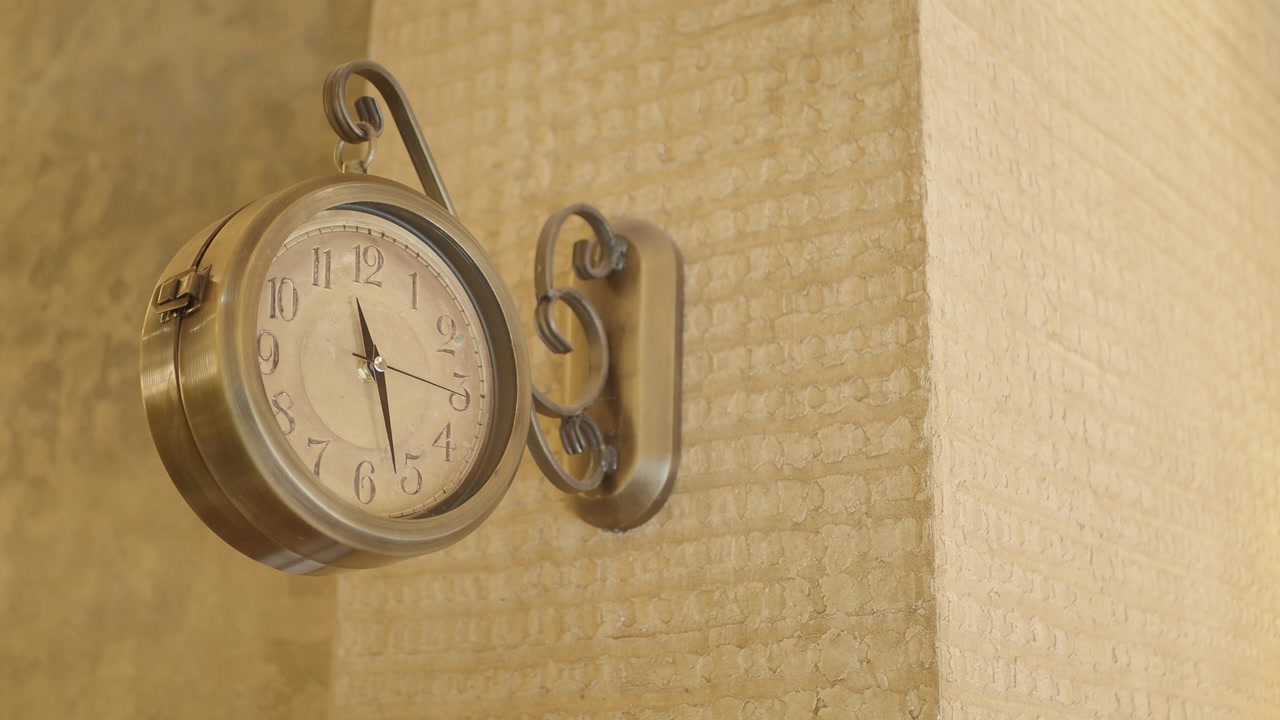 Close-up of an Antique Brass Wall Clock Ticking