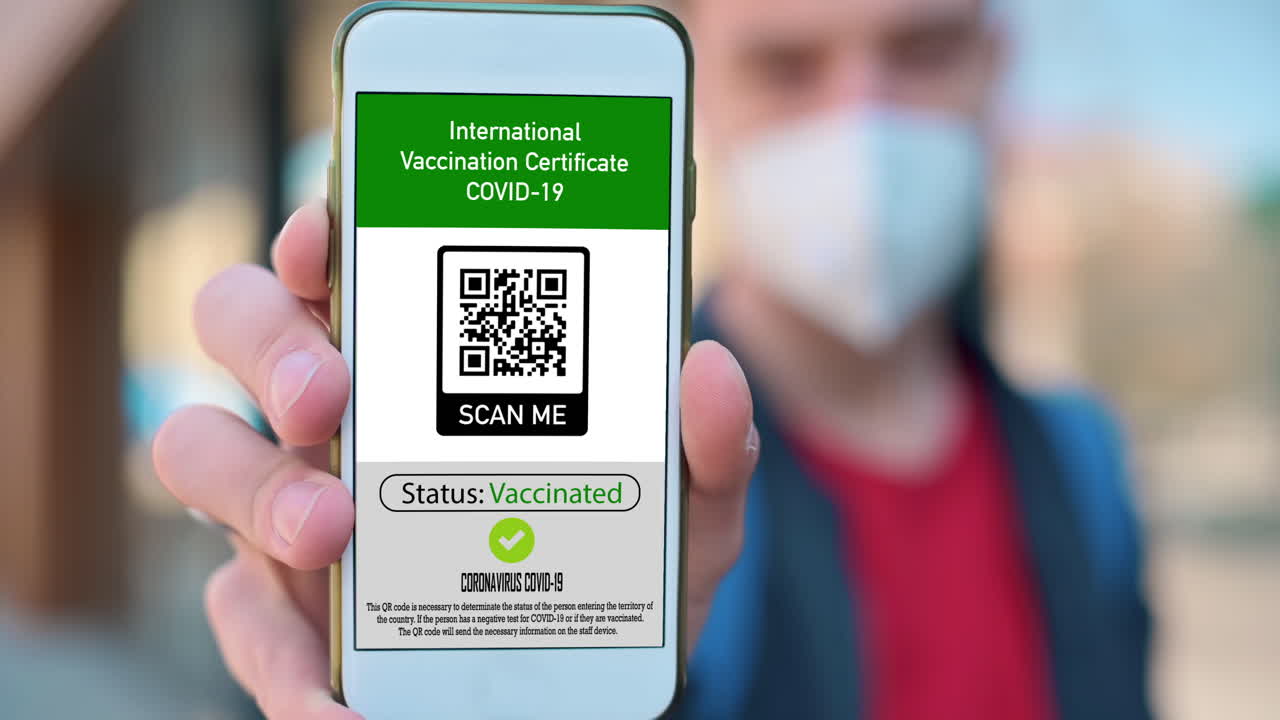 Man in medical mask showing an International Vaccination Certificate COVID-19 QR code on smartphone