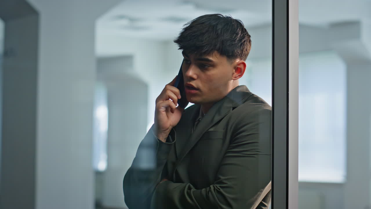 Manager negotiating cellphone call inside office building meeting room closeup