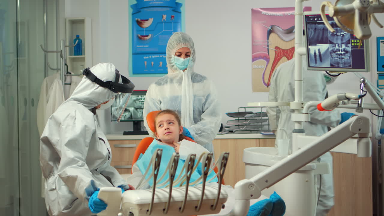 보호복을 입은 치과팀이 치과 살균 도구를 준비하고 있습니다.