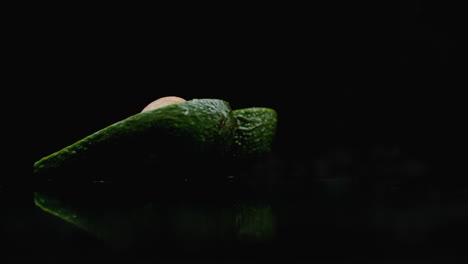 slow motion avocado with a stone falls and breaks into 2 parts with splashes.