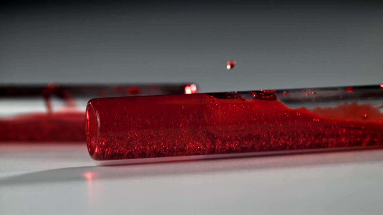 Nahaufnahme einer roten, sprudelnden Flüssigkeit in einem Reagenzglas