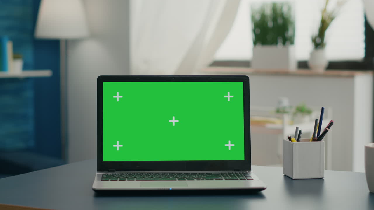Laptop computer with mock up green screen chroma key standing on home office
