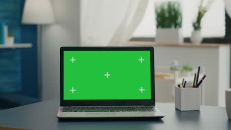 Laptop-computer-with-mock-up-green-screen-chroma-key-standing-on-home-office