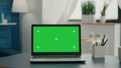 laptop computer with mock up green screen chroma key standing on home office