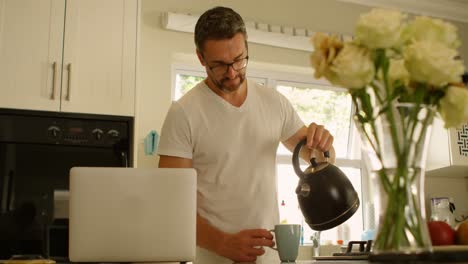 Man-pouring-water-into-coffee-cup-in-kitchen-4k