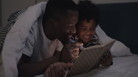 father and son reading a book together