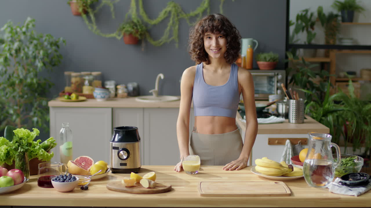 Fit Girl Drinking Fruit Smoothie and Posing for Camera