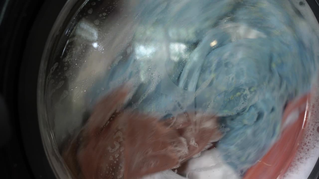 클로즈업 산업용 세탁기는 다채로운 옷과 색 린, 색 줄무 옷을 세탁합니다. 실린더 스피닝 머신. 개념 세탁기 세탁기, 산업 세탁 서비스