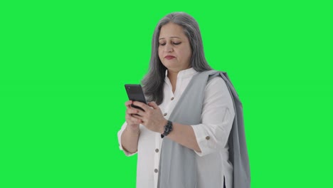 Happy-Indian-senior-businesswoman-chatting-on-phone-Green-screen