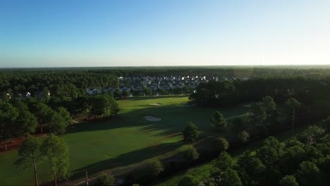 Drohne-Fliegt-Am-Frühen-Morgen-Von-Häusern-Auf-Dem-Golfplatz-Weg