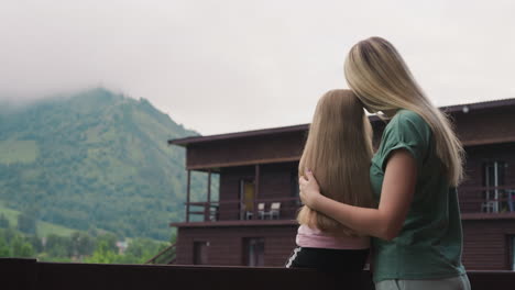 Liebevolle-Mutter-Umarmt-Kleine-Tochter-Auf-Der-Terrasse-Des-Öko-Hotels