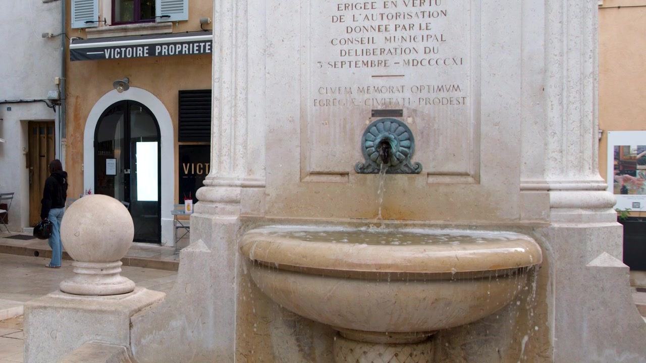 Toma media estática de agua fluyendo de una fuente de piedra clásica en Cassis, Francia