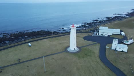 beautiful aerial of a tall lighthouse on a peaceful icelandic coast