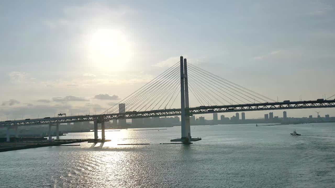 A wide shot of the Yokohama Bay Bridge taken from the cruise ship top deck, capturing ocean views and towering bridge spans