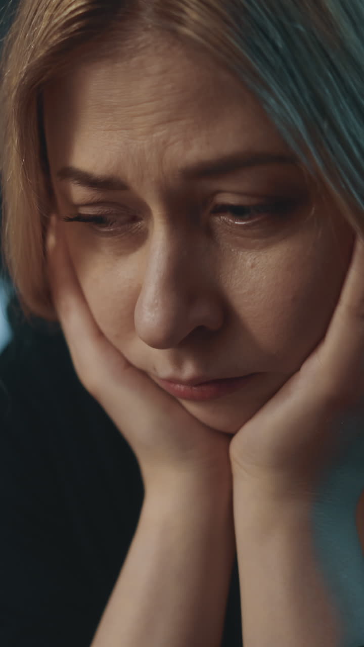 donna triste e solitaria soffre di emozioni negative a causa del divorzio appoggiandosi alle palme su uno sfondo sfocato in una stanza semi-oscura a casa estrema vista ravvicinata slow motion