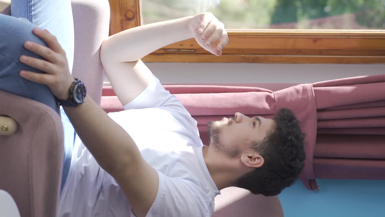 가족 문제가 있는 남자가 지루하게 앉아있는 수직 비디오.