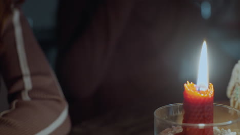 close-up capturing intimate moment as women clink cups together before taking a sip, warm candlelight glows softly, creating a cozy atmosphere