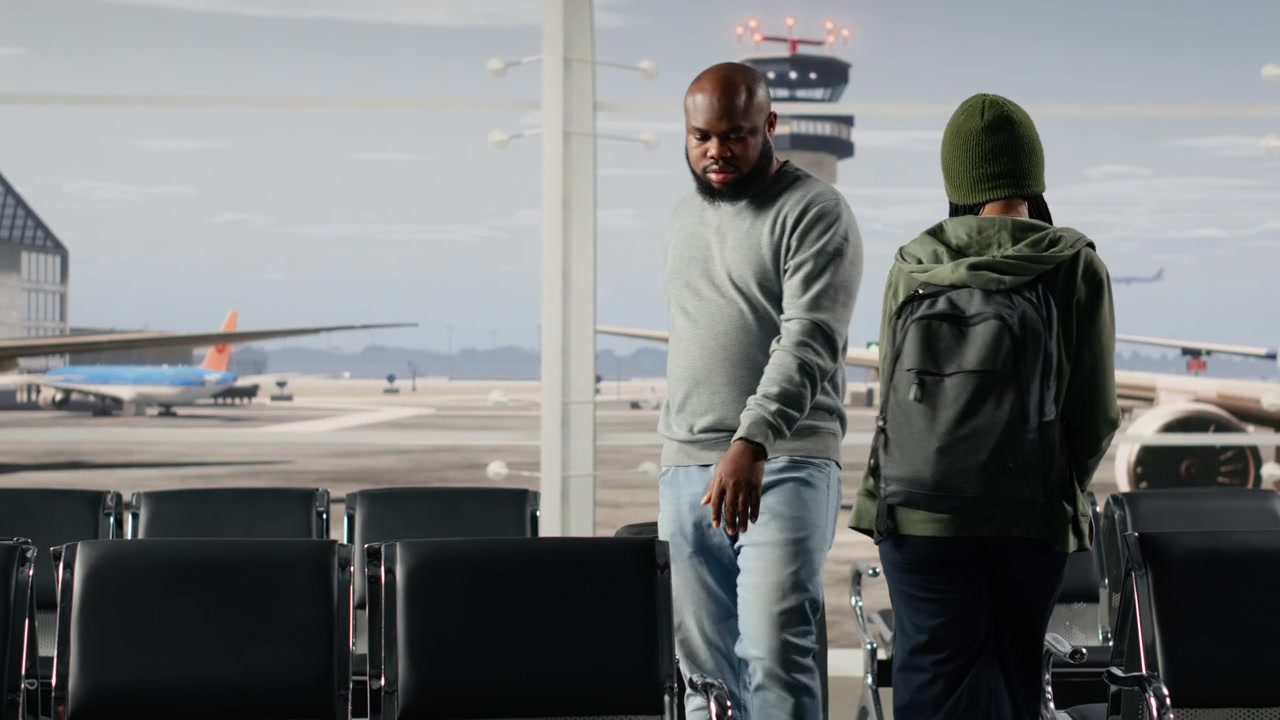 Travelers walking in busy airport departure terminal, carrying trolleys