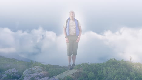 caucasian senior man hiking in countryside outstretching arms, over fast moving clouds